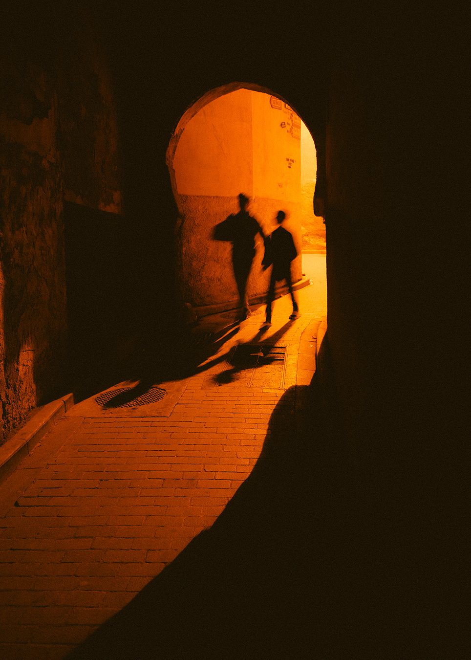 ombres et personnages dans la nuit orangée médina de Fez Maroc