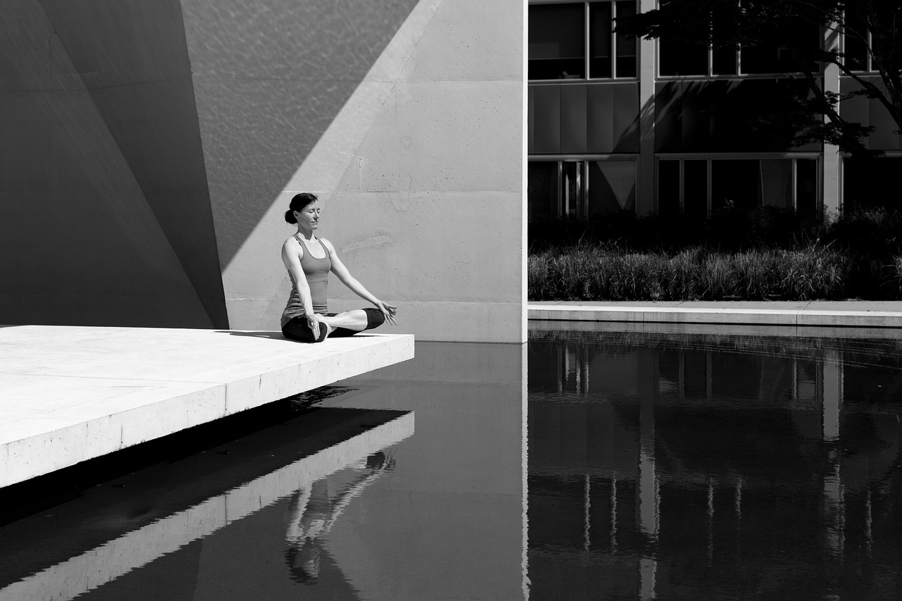 femme position du lotus en méditation devant piscine-photo noir et blanc