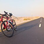 Deux vélos de route rouges arrêtés sur la piste cyclable d’Al Wathba, au cœur du désert d’Abu Dhabi