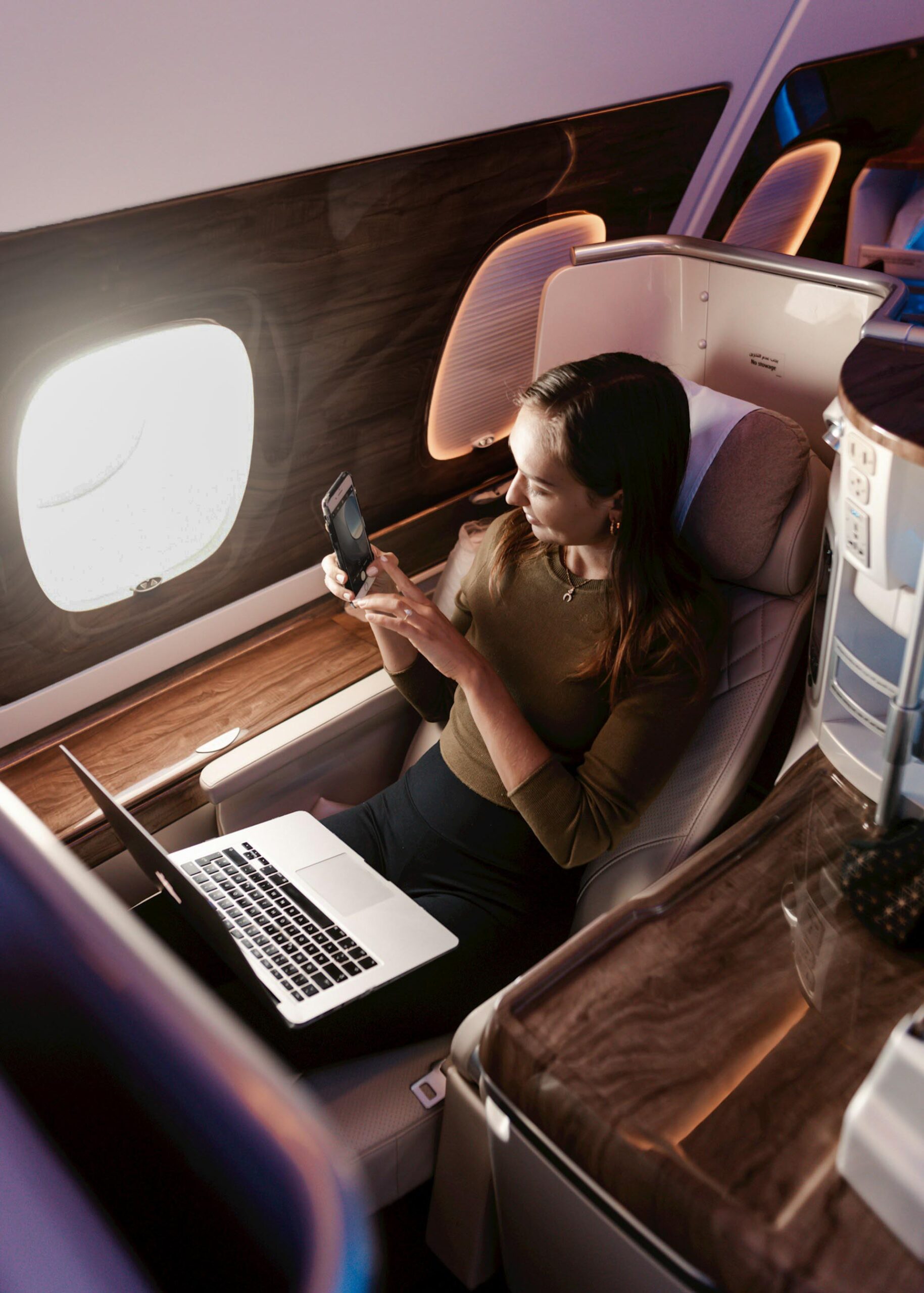Passagère assise en business class avec ordinateur ouvert devant elle