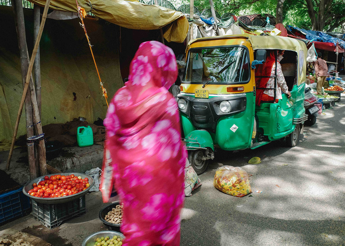 femme-sari-market-jaipur-inde-R0006521 Femme en sari rose dans un marché de Jaipur, en Inde, devant des rickshaws colorés